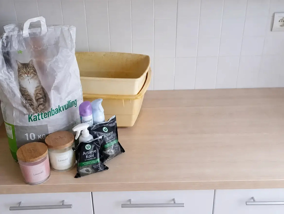 Een aanrecht vol met anti-geur arsenaal: zak kattenbakvulling, kaarsen, sprays, zakjes actieve kool