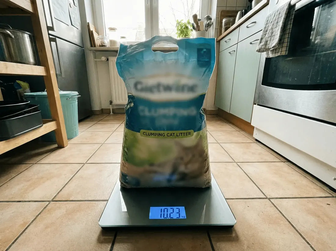 Een 10-kg-zak klontvormende kattenbakvulling op een weegschaal